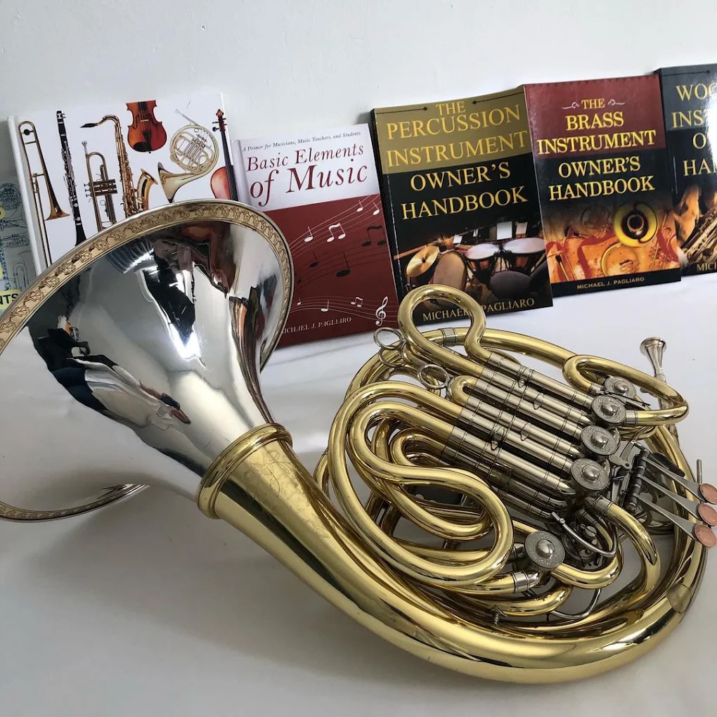 French horn displayed with music and instrument handbooks